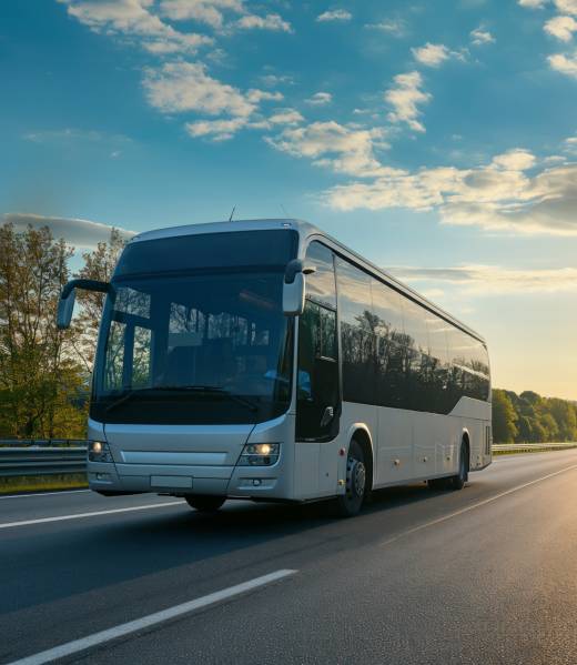 Intercity bus on highway against the backdrop of a sunset.